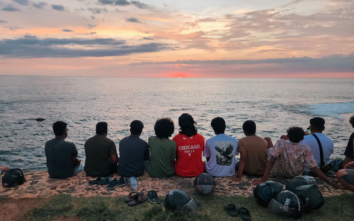 Friends watching the sunset together by the ocean